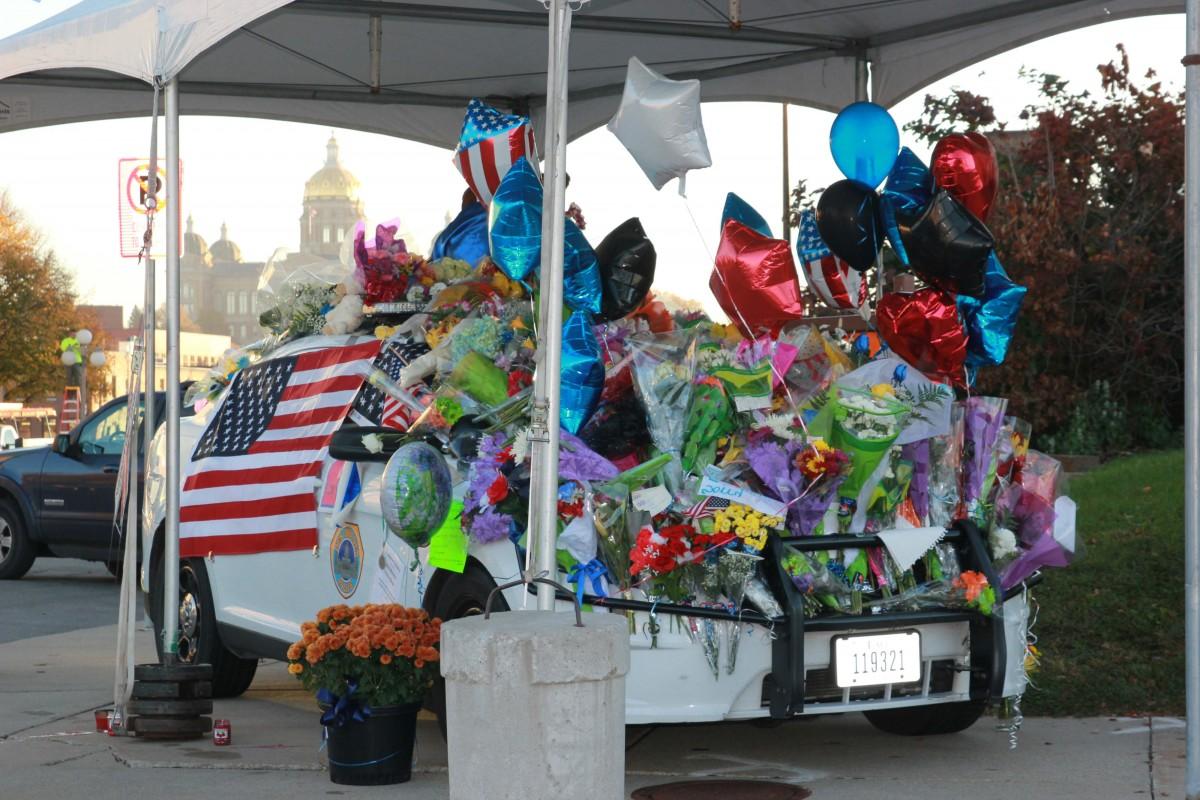 Central Iowans laid wreaths, flowers and memorabilia on a squad car, paying tribute to fallen officers Sgt. Tony Beminio and Officer Justin Martin, who were slain early Wednesday in ambush-style attacks. (Photo: Austin Hronich/The Simpsonian)