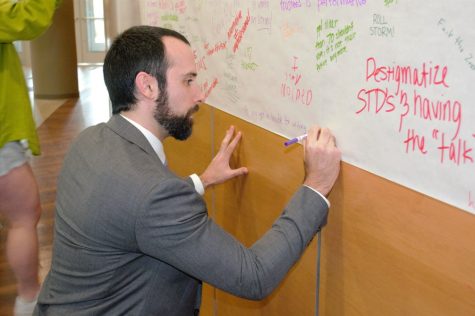 Aaron Terr, who spoke on behalf of FIRE, adds to the student media free speech wall before his speech in Hubbell Hall.