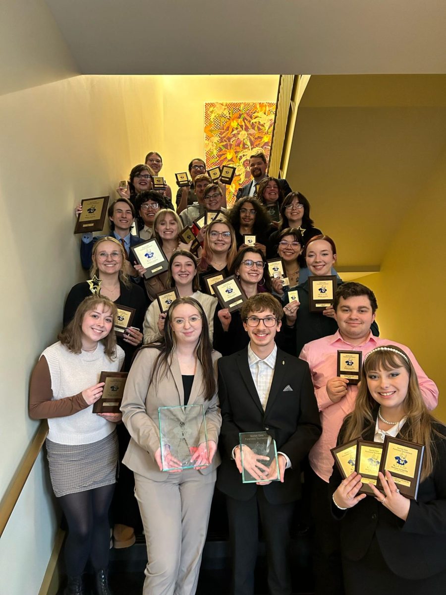 Simpsons Speech and Debate team poses proudly with the awards they received at the Gorlok Gala.