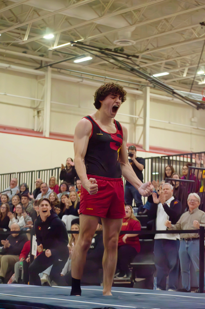 Simpson College men’s gymnast Braxton Jones celebrates after sticking his school record-breaking vault.