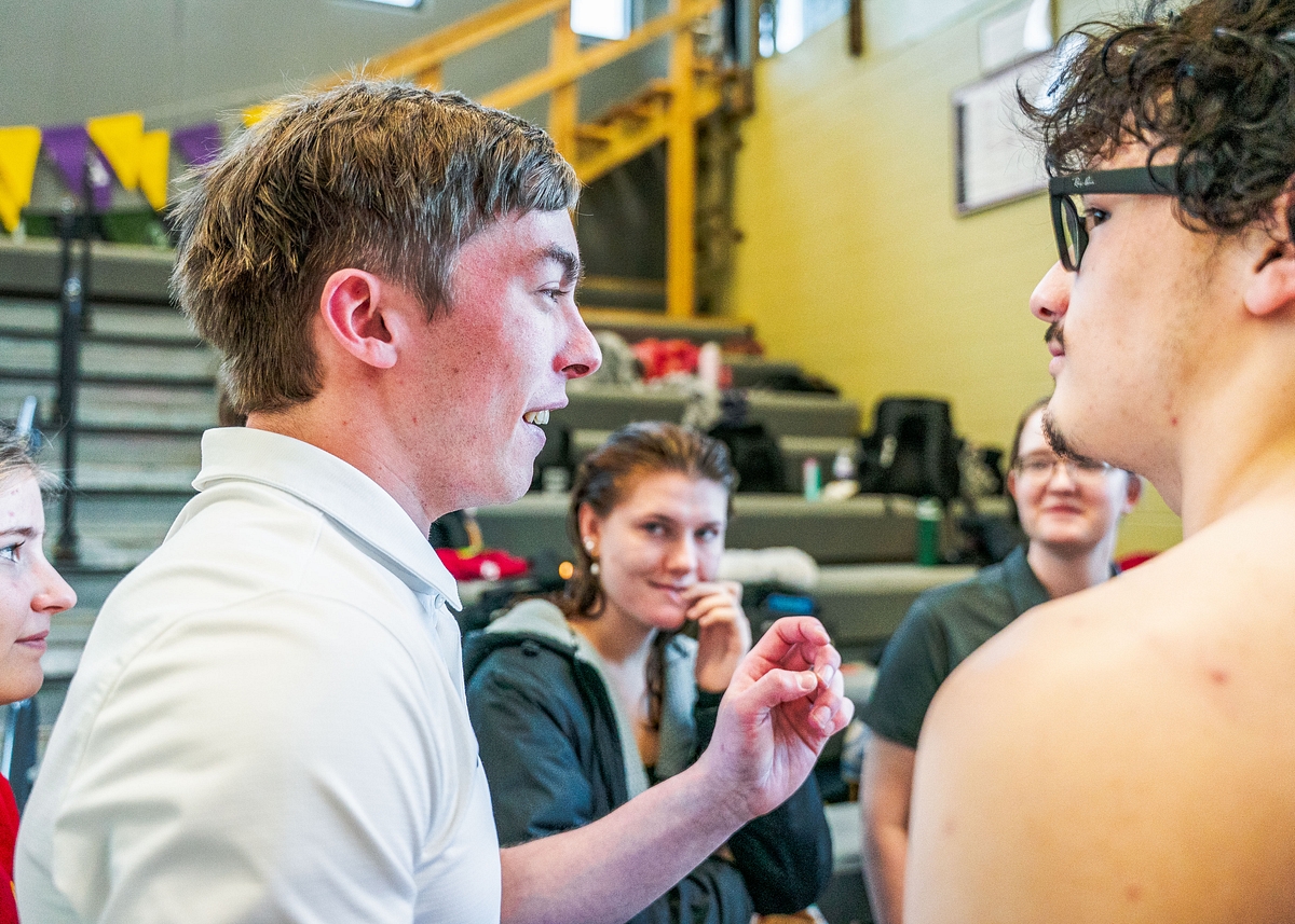 Senior Jared Oosterhuis talks with teammates during a meet