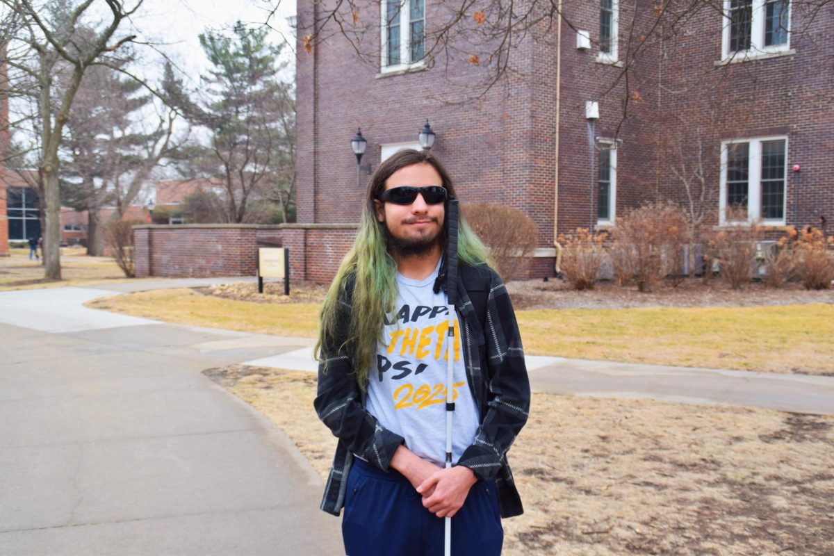 Riley Tuzzio posing for a photo outside of Dunn Library, March 5. 
