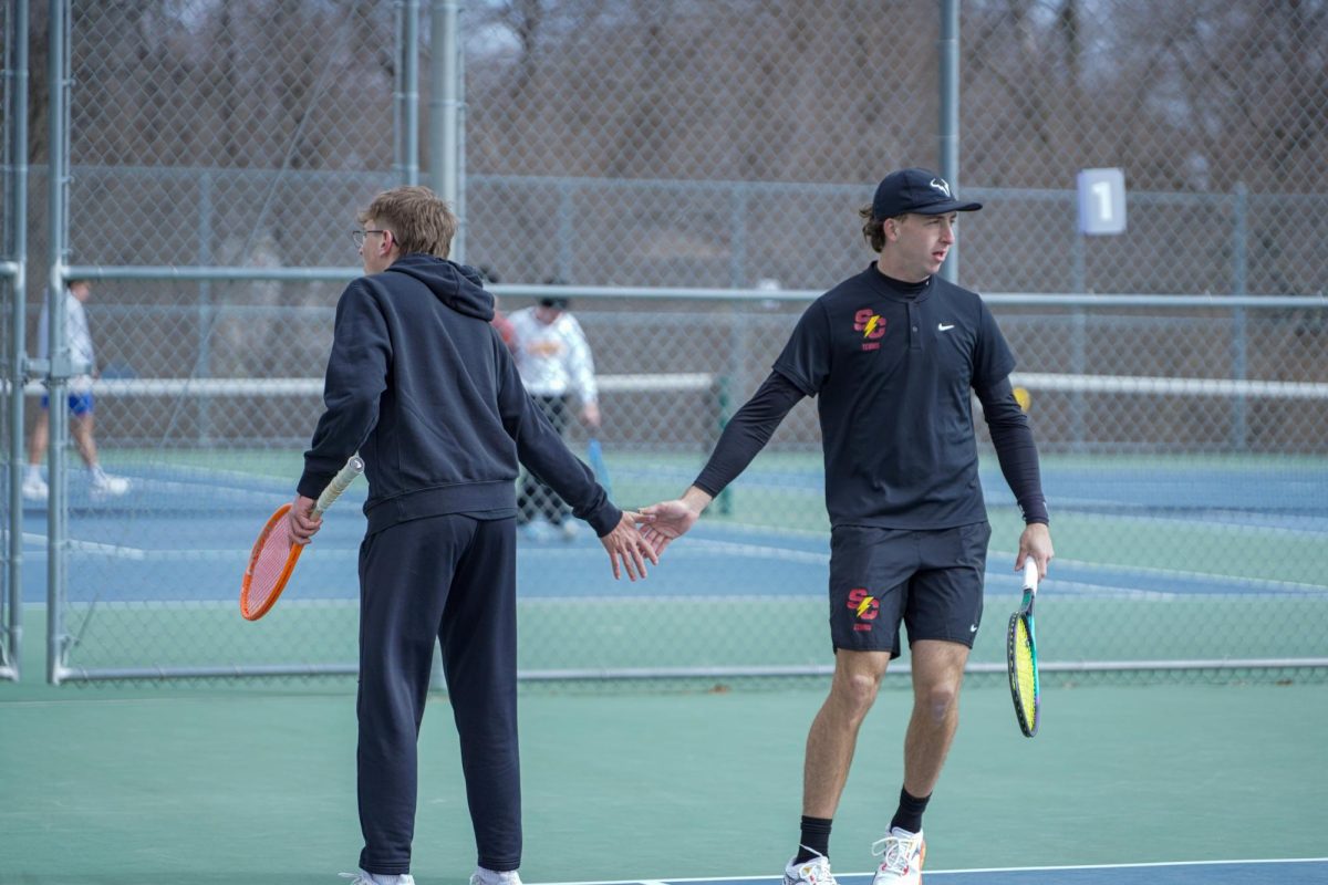 Grant Love and Hudson Christie high during doubles match